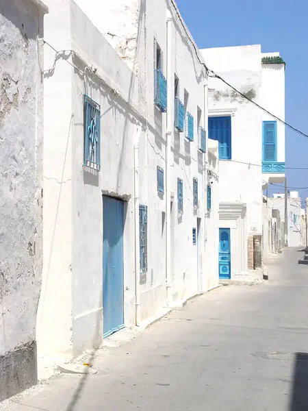 Rue déserte de Mahdia avec des portes bleues et des treillis sur le wi — Photo