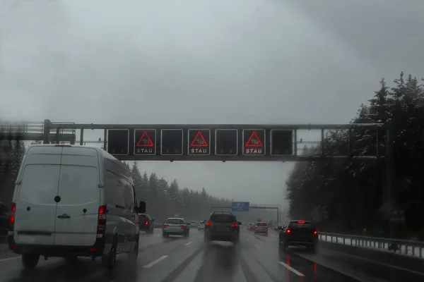 Bad weather on the Autobahn / Text on signs in German: traffic jam
