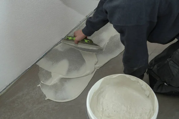 The worker installing new vinyl tile floor — Stock Photo, Image