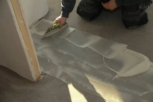 O trabalhador que instala novo piso de telha de vinil — Fotografia de Stock