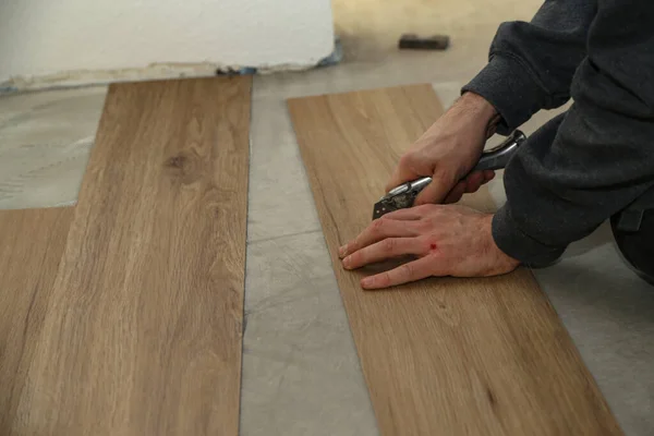 The worker installing new vinyl tile floor — Stock Photo, Image