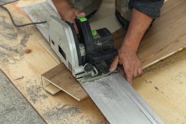 İşçi merdiven için merdiven parçalarını ölçer ve keser