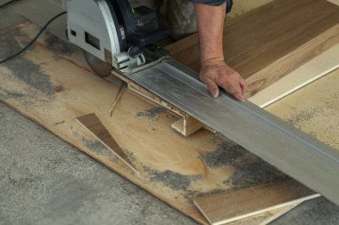 İşçi merdiven için merdiven parçalarını ölçer ve keser