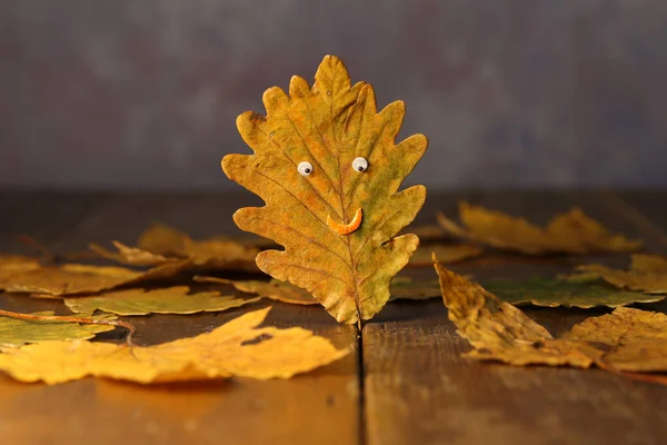 Gele herfst eiken blad in de vorm van een gezicht — Stockfoto