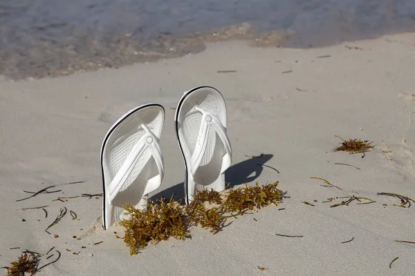 Sandalias blancas. Sandalias blancas en la playa — Foto de Stock