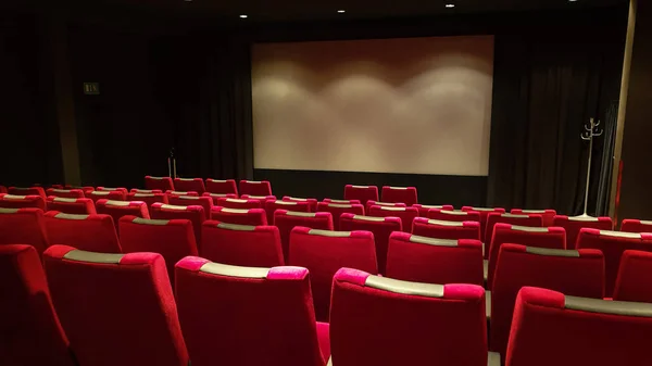 Boş sinema salonu, sinema ekranı ve kırmızı sıra oturur. — Stok fotoğraf