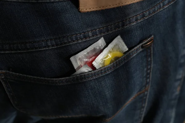 Упаковка с презервативом в джинсовом кармане — стоковое фото