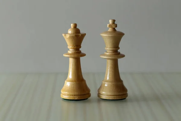 Chess pieces on a blurry light background.