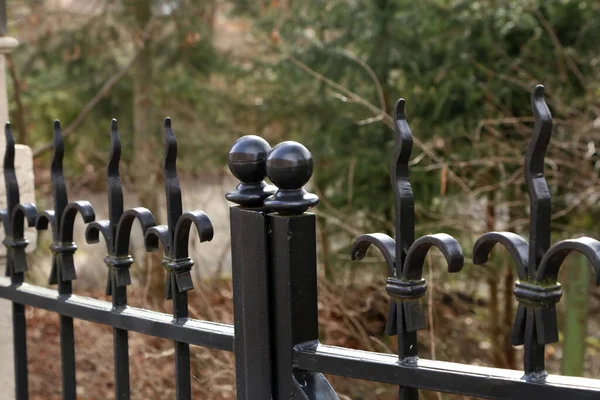 Metalowe ogrodzenie. Metalowe kręcone ogrodzenie w parku — Zdjęcie stockowe