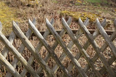 Kırsal bir evin yakınındaki bir bahçede ahşap wattle çit