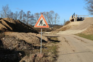 Yol tabelası bir yol köprüsünün yeniden inşası için beklemede.