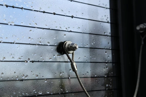 Vidrio fijado con un cable de metal y perno con tuerca — Foto de Stock