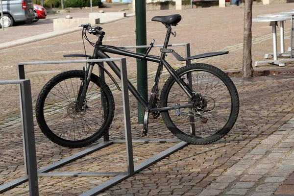 bike is fastened to rack of street fence, bike racks