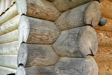 Yuvarlak kütükleri olan eski bir ahşap evin köşesinde..