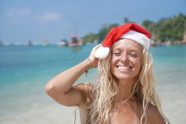 Όμορφο και πολύ ελκυστικό κορίτσι με μαγιό και καπέλο του Αϊ Βασίλη στις Μαλδίβες. Θέμα τουρισμού Χριστουγέννων και Πρωτοχρονιάς. τοπίο με γιοτ στο παρασκήνιο — Φωτογραφία Αρχείου