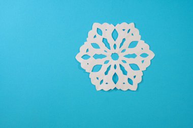 Güzel dekoratif kar taneleri mavi arka planda kağıttan kesilmiş. Fotoğraf: Noel ve Yeni Yıl Tasarımı