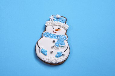 Mavi arka planda kardan adam şeklinde güzel yuvarlak zencefilli kurabiye. Kış Noel ve Yeni Yıl teması