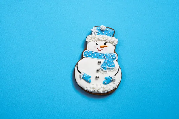 Magnifique biscuit rond en pain d'épice en forme de bonhomme de neige sur fond bleu. Thème Noël d'hiver et Nouvel An — Photo