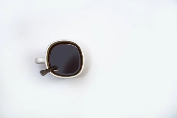 Xícara branca de café com uma colher em um fundo isolado. Bebida cappuccino preto em uma tigela — Fotografia de Stock