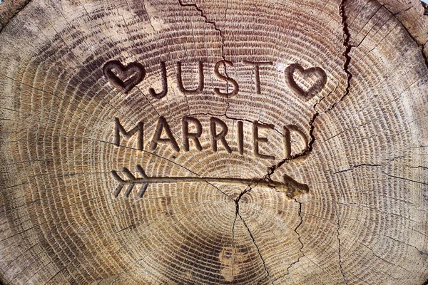 Just married. An inscription on a cut of a tree for a wedding decoration. Handmade decorative board on oak. Photo for your invitation design. — 스톡 사진