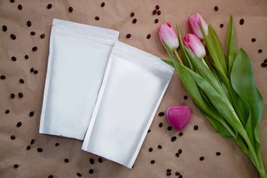 Dekorasyonun için bir paket kahve ve güzel bir bahar buketi. Paketlemedeki markanız için şablon. Logonun tasarımı için düzenName