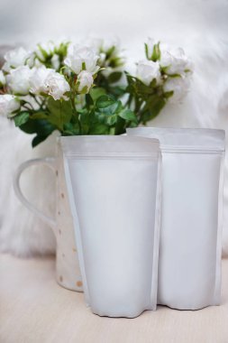 Dekorasyonun için bir paket kahve ve güzel bir bahar buketi. Paketlemedeki markanız için şablon. Logonun tasarımı için düzenName