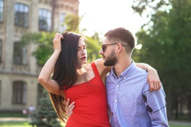 Parktaki bankta oturan güzel bir çift adam ve kadın. Bir kız ve bir erkekle romantik bir tema. Bahar Yaz teması