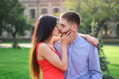 Parktaki bankta oturan güzel bir çift adam ve kadın. Bir kız ve bir erkekle romantik bir tema. Bahar Yaz teması
