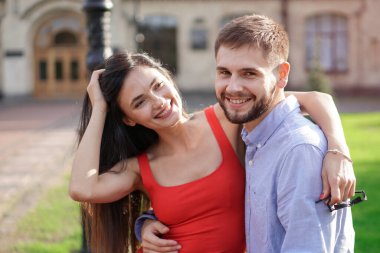 Parktaki bankta oturan güzel bir çift adam ve kadın. Bir kız ve bir erkekle romantik bir tema. Bahar Yaz teması