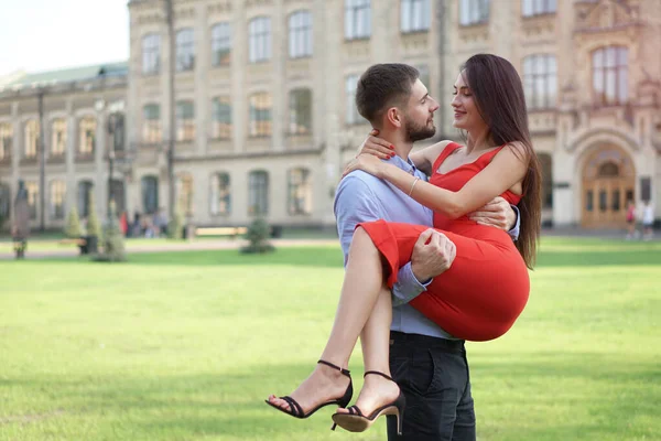 Beautiful couple of man and woman on a blurry background of a beautiful park. Romantic theme with a girl and a guy. Spring, summer picture relationship, love, Valentines day