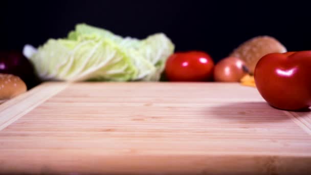 Cortar un tomate en una tabla de cortar . — Vídeos de Stock