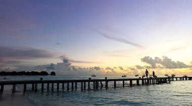 Günbatımı güzel gökyüzü arka plan ile sahilde.