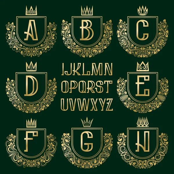 Kit de escudo de armas real con dibujos. Letras doradas y marcos de corona ornamentales para crear el logotipo inicial en estilo vintage . — Vector de stock