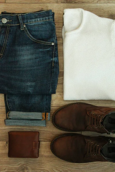 Set of casual men clothes and accessories on wooden background. Top view.