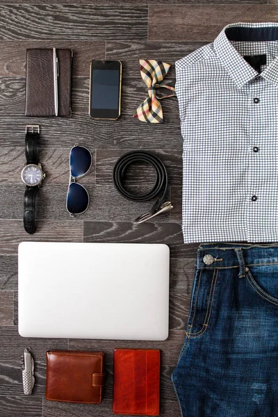 Conjunto de ropa casual para hombre y accesorios sobre fondo de madera negro oscuro. Vista superior . —  Fotos de Stock