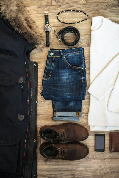 Set of casual winter men clothes and accessories on wooden background. Top view.