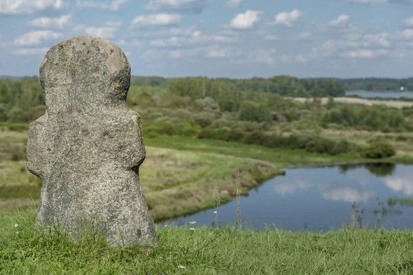 Ancienne croix religieuse en pierre sur une colline en arrière-plan de la rivière — Photo