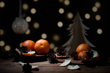 Noel arka plan - mandalina, tarçın, kase, karanlık bokeh ile ahşap ağaç