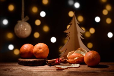 Noel arka plan - mandalina, tarçın, kase, karanlık bokeh ile ahşap ağaç