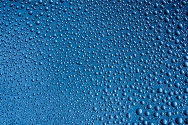 Vidro enevoado com gotas de água em um fundo azul — Fotografia de Stock