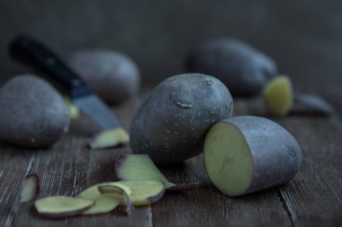taze patates yumru ve rustik tarzda ahşap masa üzerinde bir bıçakla kesilmiş parçalar