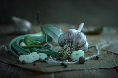 Baş sarımsak, sarımsak, defne yaprağı üzerinde ahşap tahta koyu arka plan