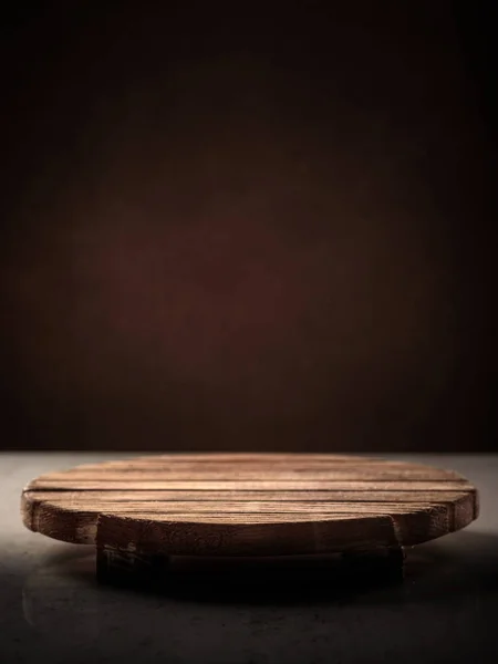 Cavalletto rotondo in legno per l'amarezza del cibo su uno sfondo scuro, posto per iscrizione, copertura — Foto Stock