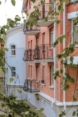 Ferforje balkon arka plan yeşil yaprakların üzerinde tuğla cephe evler