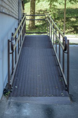 tekerlekli sandalye ve binanın girişinde engelliler için rampa