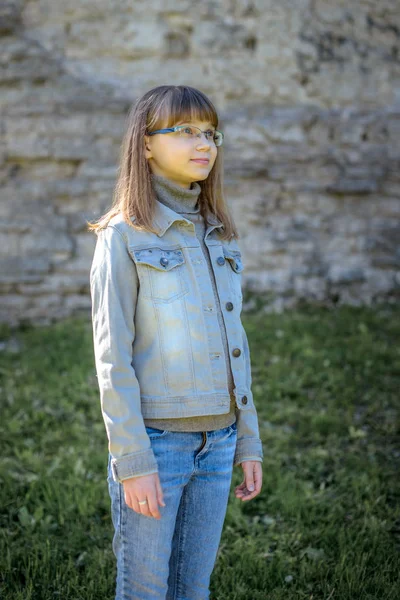 Estilo jovem urbano. Menina adolescente com óculos no fundo da parede de pedra — Fotografia de Stock