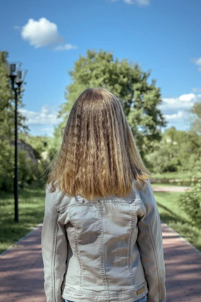 Jeune fille adolescente se tient avec son dos avec des cheveux sains, longs et blonds — Photo