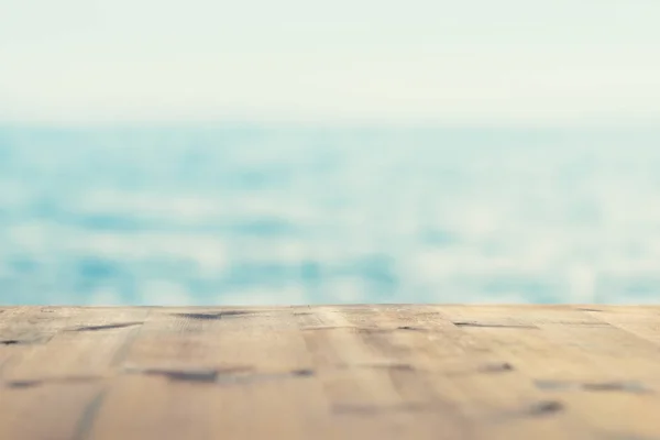 Summer background of empty wooden table in background of sea and sky in soft focus — Stock Photo, Image