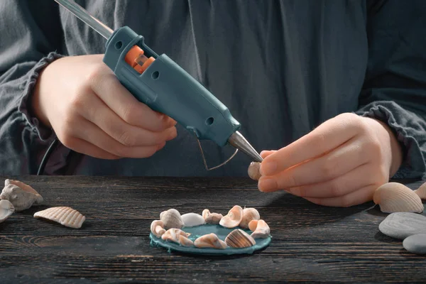 Woman make shell magnet with melt glue gun — Stock Photo, Image