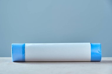 Gri arkaplanda kopyalama alanı olan mavi çöp torbalarını yuvarla.